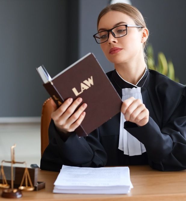 mujer con gafas y libro de leyes
